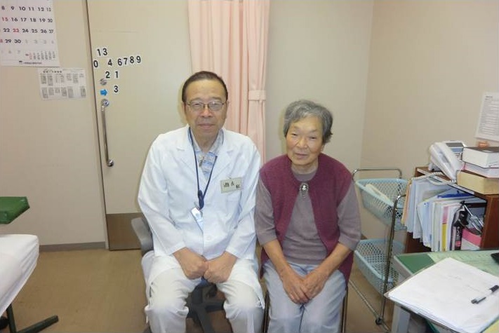 病院の外来で、瀬古先生と高齢の患者さん。